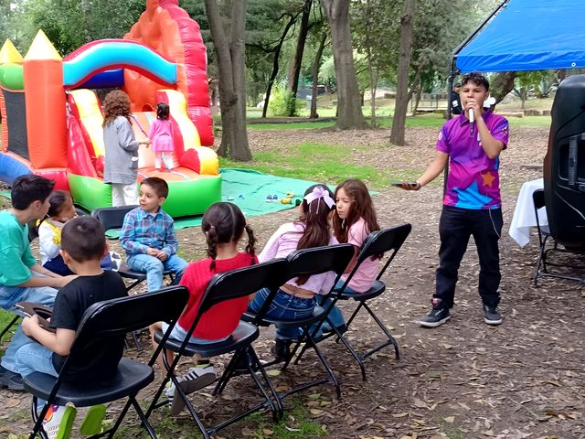 Niños sentados frente a un inflable en un parque