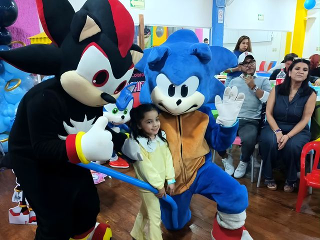 Dos personajes con una niña en una fiesta