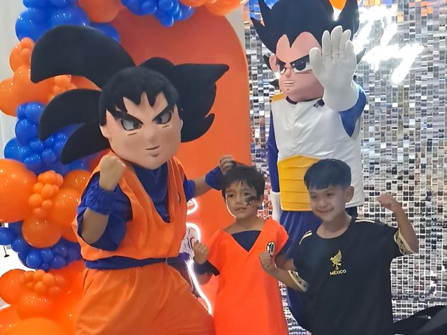 Personajes con niños frente a una decoración de globos