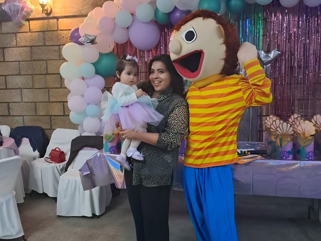 Personaje con una familia frente a un arco de globos